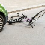 A bicycle and cycle helmet lay in the road following a collision with a car