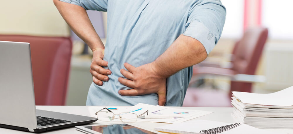 Man suffering back pain at work